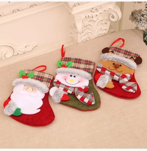 Three plush Christmas stockings with Santa, Snowman and Reindeer on a fireplace mantel