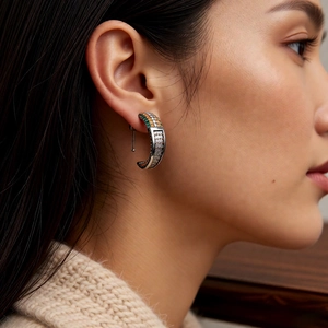 Close-up of vintage silver C-shaped earrings with colorful pavé cubic zirconia gemstones