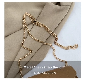 Detailed macro view of the gold-tone metal chain strap on khaki embossed crossbody bag