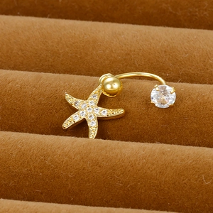 Macro view of gold starfish belly ring with white cubic zirconia on velvet stand