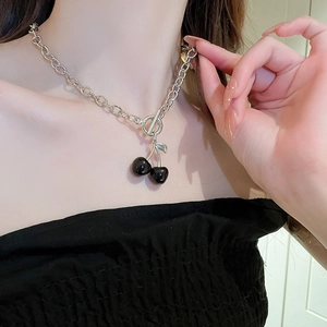 Detail of silver chain necklace featuring a black cherry pendant and OT toggle clasp