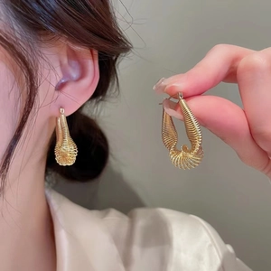 Gold twisted wire hoop earrings for women with minimalist aesthetic and textured finish