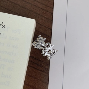 Detailed view of S925 sterling silver leaf ring on vintage book and wooden table background