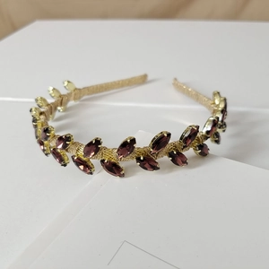 Detailed view of purple marquise crystal hairband with gold wire wrap design