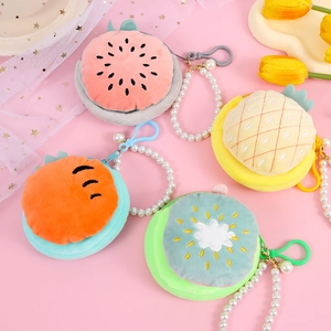 Detail of plush fruit coin purses with pearl chains and colorful plastic hooks on pink background