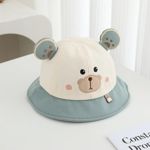 Dettaglio del ricamo a forma di orso e della trama della tela sul cappello da sole per bambini