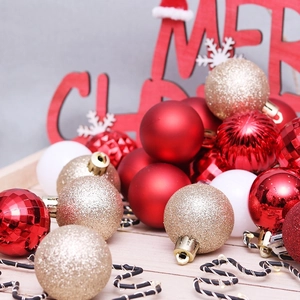 Assorted red and gold Christmas ball ornaments set on a wooden tray for tree decoration