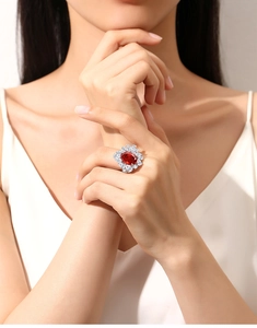 Macro view of oval ruby red gemstone ring with halo of brilliant white diamonds