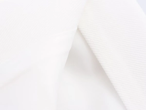 Macro shot showing the white linen blend fabric texture and twill weave of the trousers