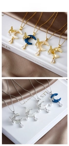 Detailed view of moon and butterfly pendants with pearls and rhinestones on steel chains