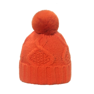 Detailaufnahme der orangefarbenen Strickmütze mit passendem flauschigem Bommel-Detail