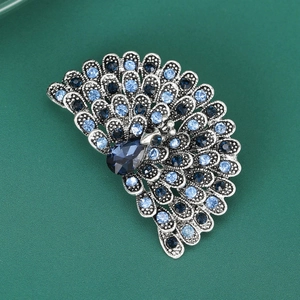 Close-up of vintage silver peacock brooch with sparkling blue and navy rhinestones