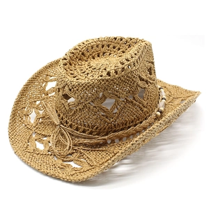 Détail du chapeau de cowboy en paille tressée avec motifs de cœurs et perles déco