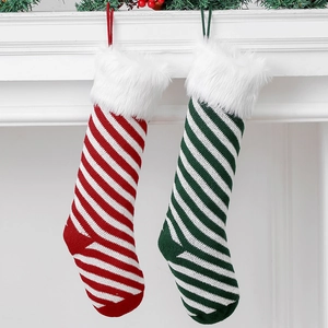 Detail of red and green striped knit Christmas stockings hanging on a white mantelpiece
