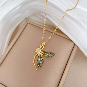 Luxurious gold dragonfly necklace with iridescent wings and sparkling crystals on silk
