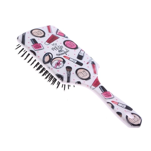 Detail of large cushion hairbrush with white makeup patterns and black bristles