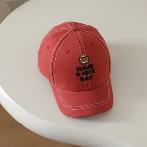 Detailed embroidery of bear with crown and contrast stitching on red baseball cap