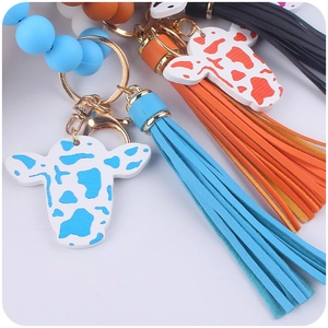 Detail of cow print pendants and matching tassels on silicone beaded keychains