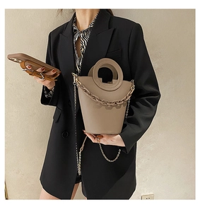 Detail of khaki bucket bag with decorative acrylic chain and metallic shoulder strap