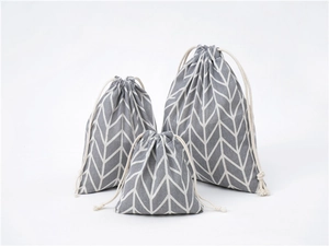 Three-piece set of linen drawstring bags with grey and white geometric chevron patterns
