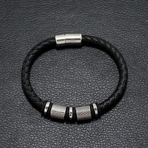 Detail of black braided leather bracelet with silver magnetic clasp and textured beads