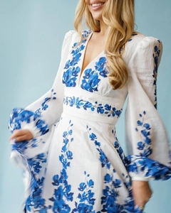 Detailed view of white V-neck floral dress with blue embroidery and lantern sleeves