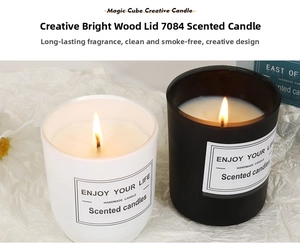 Close-up of minimalist scented soy candle in matte glass jar with wooden lid and flame