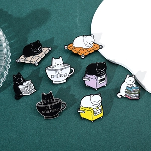 Macro shot of 8 enamel cat pins featuring coffee, books, and toaster scenes