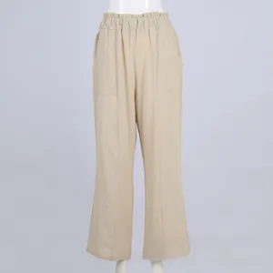 Dettaglio di pantaloni beige in cotone e lino con vita alta elastica e tasche laterali