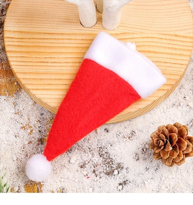 Mini red felt Santa hat cutlery holder on wooden base with pine cones and snow
