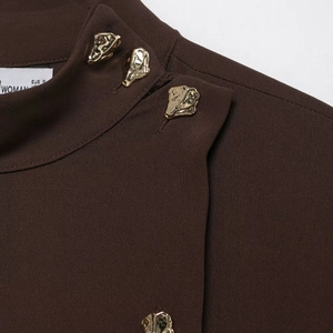 Elegant sleeveless dark brown high-neck top with gold button detailing and waist belt