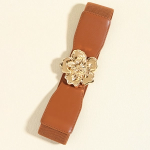 Détail d'une ceinture élastique marron avec boucle dorée en forme de fleur