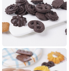 Detailed view of various faux chocolate cookies and biscuit charms on a white tray