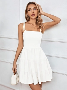 Close-up of adjustable bow shoulder straps and layered tiers on white summer dress