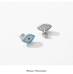 Macro shot of silver S925 Evil Eye stud earrings with turquoise and zircon stone inlays