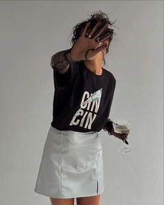 Détail du t-shirt noir en coton avec imprimé CIN CIN et jupe en cuir argenté sur mannequin