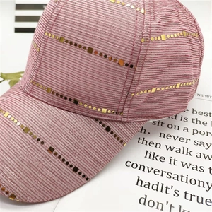 Close-up of pink baseball cap featuring ribbed fabric and gold sequin embellishments