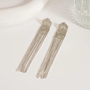 Macro view of silver tassel earrings with multiple fine chains and geometric bead top