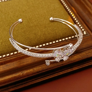 Detail von silberner Manschette mit Zirkonia-Schmetterling und funkelnden Steinschichten
