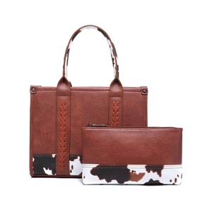 Conjunto de bolso y neceser de ecopiel marrón con estampado de vaca y asa tejida