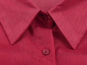 Détail du col et de la patte de boutonnage d'un chemisier en mousseline rouge foncé texturé