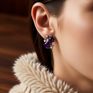 Nahaufnahme von Vintage-Blumenohrringen mit lila Steinen und Strasssteinen an Modell