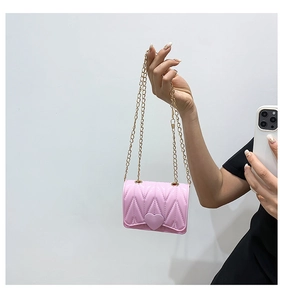 Detailed macro of pink heart silicone mini crossbody bag with gold chain and V-pattern