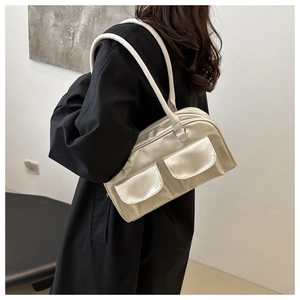 Close-up of cream faux leather shoulder bag with glossy finish and double front pockets