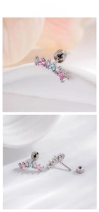 Macro detail of curved ear studs with pink, blue, and purple marquise-cut zircons
