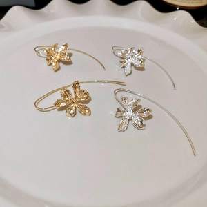 Vintage iris flower drop earrings in gold and silver finish on a white ceramic plate
