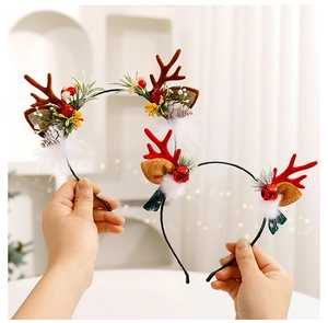 Detail of Christmas reindeer antler headbands with pine cones and red berry decorations