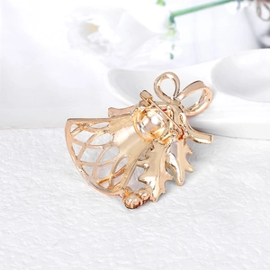 Golden Christmas bell brooch with bow and holly design on elegant white background