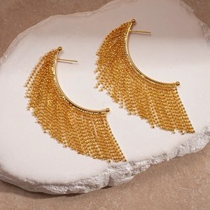 Elegant gold-tone beaded tassel drop earrings displayed on a minimalist stone base