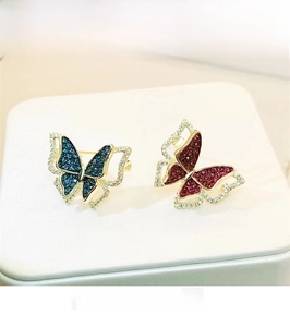 Detailed macro view of red and blue butterfly brooches with zircon on leather